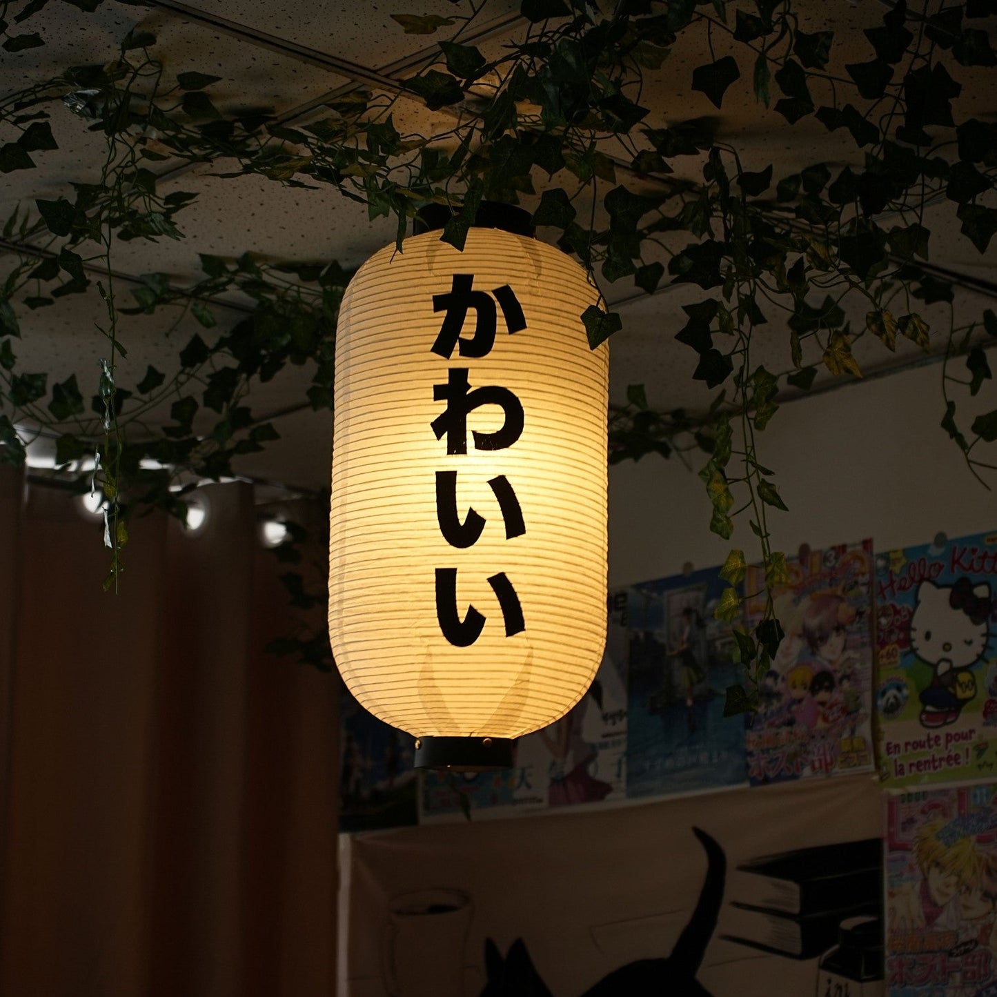 Paper lantern with Japanese text hanging among plants indoors